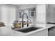 Modern kitchen with stainless steel appliances, quartz countertops, and a stylish faucet, offering a sleek design at 10292 Fragrant Apple Ct, Las Vegas, NV 89141