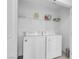 Bright laundry room with shelving and modern side-by-side washer and dryer at 10292 Fragrant Apple Ct, Las Vegas, NV 89141