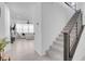 Open-concept view of living room and staircase with light tile floors and a comfortable white sofa at 10292 Fragrant Apple Ct, Las Vegas, NV 89141