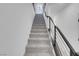 Carpeted staircase with modern metal railing and white walls, creating an open and bright transition between floors at 10292 Fragrant Apple Ct, Las Vegas, NV 89141