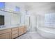 Bright bathroom featuring double sinks, a stand up shower, and separate tub at 10628 Mission Lakes Ave, Las Vegas, NV 89134