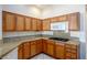 Charming kitchen featuring wooden cabinets, granite countertops, and modern appliances at 10628 Mission Lakes Ave, Las Vegas, NV 89134