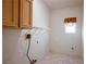 Practical laundry area with tile floor, overhead shelf, and essential utility connections at 10628 Mission Lakes Ave, Las Vegas, NV 89134