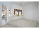 Empty living room features a large window with decorative drapes and a view of the yard at 10628 Mission Lakes Ave, Las Vegas, NV 89134