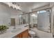 Functional bathroom with a tub-shower combination featuring a glass enclosure, complemented by a wood vanity at 10952 Napa Ridge Dr, Las Vegas, NV 89144