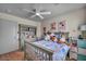 Comfortable bedroom with ceiling fan, dresser with display shelving, and natural light at 10952 Napa Ridge Dr, Las Vegas, NV 89144