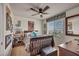 Inviting bedroom with a wooden bed frame, ceiling fan, and charming decor, flooded with natural light from the window at 10952 Napa Ridge Dr, Las Vegas, NV 89144