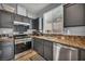 Modern kitchen featuring granite countertops, stainless steel appliances, and dark cabinets at 10952 Napa Ridge Dr, Las Vegas, NV 89144