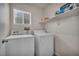 Efficient laundry room with a modern washer and dryer set, and convenient shelving for storage at 10952 Napa Ridge Dr, Las Vegas, NV 89144