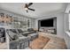 Comfortable living room featuring a large gray sectional sofa, TV, ceiling fan, and natural light at 10952 Napa Ridge Dr, Las Vegas, NV 89144