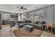 Open concept living space with a large gray sectional, ceiling fan, and adjacent kitchen area at 10952 Napa Ridge Dr, Las Vegas, NV 89144