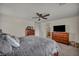 Spacious main bedroom with a ceiling fan, ensuite bathroom, carpet flooring and a television at 10952 Napa Ridge Dr, Las Vegas, NV 89144