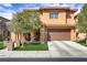 Inviting two-story home with a well-maintained lawn, a spacious driveway, and a mature tree in the front yard at 1272 Olivia Pkwy, Henderson, NV 89011