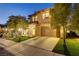 Elegant two-story home with manicured lawn and mature trees at dusk at 1272 Olivia Pkwy, Henderson, NV 89011