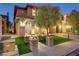 Charming two-story home with manicured front yard and decorative brick features, illuminated by elegant outdoor lighting at 1272 Olivia Pkwy, Henderson, NV 89011
