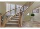 Elegant curved staircase with wrought iron railing, light colored carpet, and plantation shutters allowing natural light at 1272 Olivia Pkwy, Henderson, NV 89011