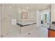 Bright bathroom featuring a soaking tub, a seamless glass shower, and a peek into an adjacent bedroom at 135 E Harmon Ave # 1401, Las Vegas, NV 89109