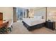 This bedroom has a large bed, a work desk, and city views from floor-to-ceiling windows at 135 E Harmon Ave # 1401, Las Vegas, NV 89109