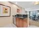 Convenient kitchenette features a stainless dishwasher, sink, granite counters, and wood cabinetry at 135 E Harmon Ave # 1401, Las Vegas, NV 89109