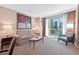 Cozy living room with comfortable seating, balcony access, and a view of the city skyline at 135 E Harmon Ave # 1401, Las Vegas, NV 89109
