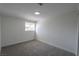 This bedroom has neutral decor, gray carpet, white walls, and a window at 1413 Culley St, Las Vegas, NV 89110