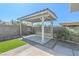 A covered carport with white supports, located in a backyard setting with brick accents at 1413 Culley St, Las Vegas, NV 89110