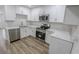 Contemporary kitchen featuring white cabinetry, marble countertops, and stainless steel appliances at 1413 Culley St, Las Vegas, NV 89110