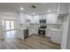 Renovated kitchen with white cabinets, stainless steel appliances, wood-look flooring, and plenty of natural light at 1413 Culley St, Las Vegas, NV 89110