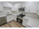 Bright kitchen featuring stainless steel appliances, white marble countertops, and light wood-look floors at 1413 Culley St, Las Vegas, NV 89110