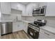 Updated kitchen with white cabinets, marble countertops, gold hardware, and stainless steel appliances at 1413 Culley St, Las Vegas, NV 89110