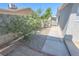 A simple side yard featuring gravel, pavers, and greenery along a block wall at 1413 Culley St, Las Vegas, NV 89110