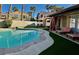 Private backyard oasis with a sparkling pool, lounge chairs, and verdant landscaping at 1704 Cordoba Canyon St, Las Vegas, NV 89117