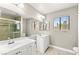 Bright bathroom featuring double sinks, a glass-enclosed shower, and a large mirror at 2062 Club Crest Way, Henderson, NV 89014