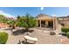 A well-maintained backyard with a patio cover, landscaping, rock features, and a small bench at 2120 Desert Woods Dr, Henderson, NV 89012