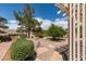 Landscaped backyard featuring a stone bench, pergola, and lush greenery at 2120 Desert Woods Dr, Henderson, NV 89012