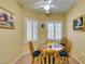 Cozy breakfast nook features a round wood table, four chairs and two windows at 2120 Desert Woods Dr, Henderson, NV 89012