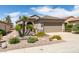Charming single-story home boasting desert landscaping, including palm trees and cacti, a two car garage, and a welcoming facade at 2120 Desert Woods Dr, Henderson, NV 89012