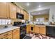 Functional kitchen area with oak cabinets, black appliances, and ample counter space, perfect for everyday cooking at 2120 Desert Woods Dr, Henderson, NV 89012