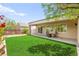 Inviting backyard with lush green lawn, covered patio, and cozy seating area, perfect for outdoor relaxation at 2227 Garden City Ave, Henderson, NV 89052