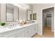 Bright, dual vanity bathroom with ample cabinet space and a glimpse into a spacious walk-in closet at 2227 Garden City Ave, Henderson, NV 89052