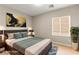 Neutral bedroom features a queen-sized bed, abstract art, and natural light from a window at 2227 Garden City Ave, Henderson, NV 89052