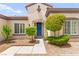 Beautiful home exterior with manicured landscaping, an inviting stone archway, and a vibrant blue front door at 2227 Garden City Ave, Henderson, NV 89052