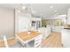 Open-concept kitchen featuring white cabinets, stainless steel appliances, island, and adjoining dining area at 2227 Garden City Ave, Henderson, NV 89052