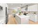 Modern kitchen boasts stainless steel appliances, white cabinetry, an island and wood flooring at 2227 Garden City Ave, Henderson, NV 89052