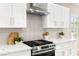 Close-up of the kitchen featuring stainless steel appliances, white cabinets, and modern backsplash at 2227 Garden City Ave, Henderson, NV 89052