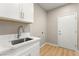 Bright laundry room boasts white cabinets, laminate flooring, and modern fixtures at 2227 Garden City Ave, Henderson, NV 89052