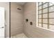Luxurious tiled shower with a glass block window, rain shower head, and convenient shower niche at 2227 Garden City Ave, Henderson, NV 89052