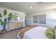 Brightly lit bedroom showcases a dresser, plant, two paintings, and a comfortable bed at 2630 Begonia Falls Ave # 37, North Las Vegas, NV 89081