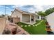 Well-maintained backyard featuring low maintenance landscaping and artificial turf and a covered patio at 3157 Capetown Way, Las Vegas, NV 89128
