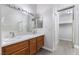 This bathroom boasts dual sinks, a large mirror with updated vanity lights, and updated fixtures for a luxurious feel at 3157 Capetown Way, Las Vegas, NV 89128